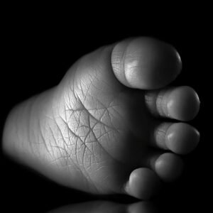 The Precious Treasure fine art print — newborn baby foot black and white macro low-key photography